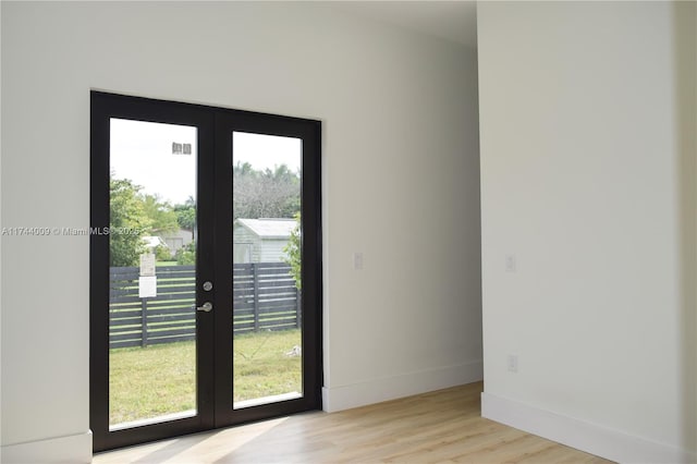 doorway featuring french doors, baseboards, and wood finished floors