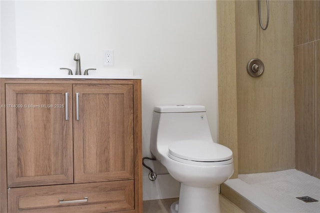 bathroom featuring tiled shower, vanity, and toilet