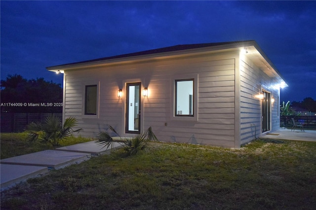 view of front of house featuring a patio area, a yard, and fence