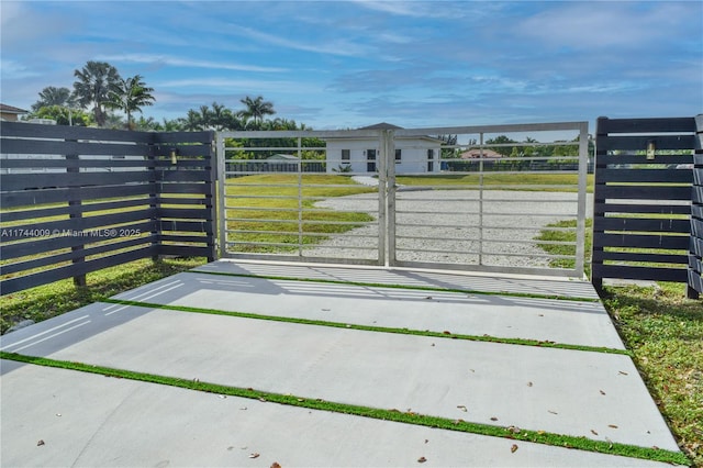 view of gate featuring a yard and fence