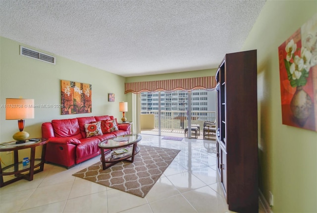 living area featuring visible vents, a textured ceiling, and light tile patterned flooring