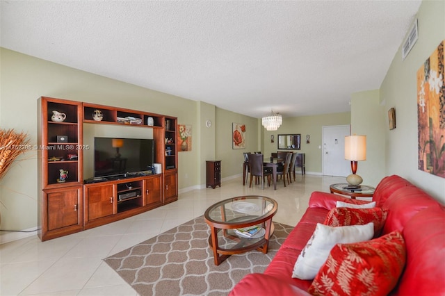 living area featuring an inviting chandelier, visible vents, a textured ceiling, and light tile patterned flooring