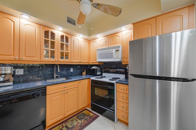 kitchen with black appliances, dark stone countertops, a sink, and glass insert cabinets