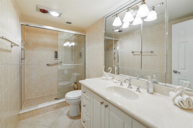 bathroom with visible vents, toilet, a stall shower, vanity, and tile patterned flooring