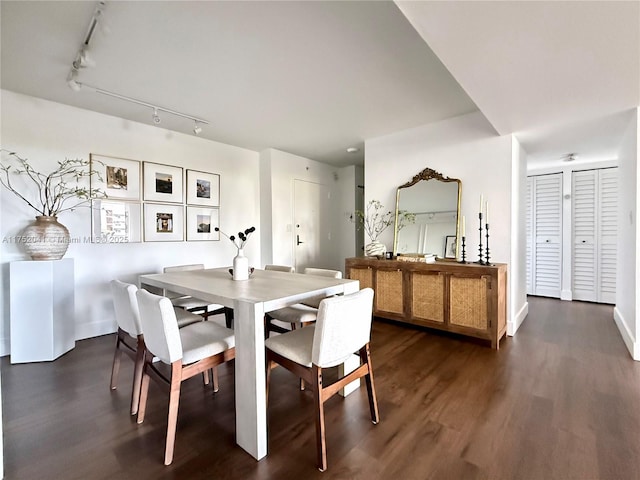 dining room featuring dark wood-type flooring and track lighting