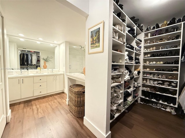 spacious closet with light wood-type flooring and a sink