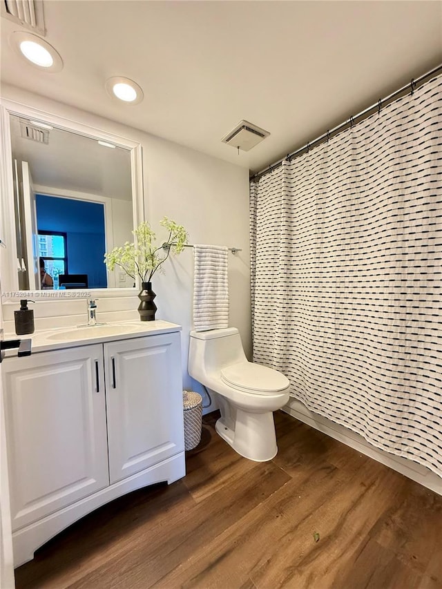 ensuite bathroom featuring visible vents, toilet, wood finished floors, ensuite bathroom, and vanity