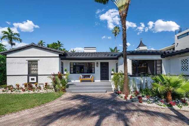 view of front of property featuring a garage, stucco siding, decorative driveway, and a front yard