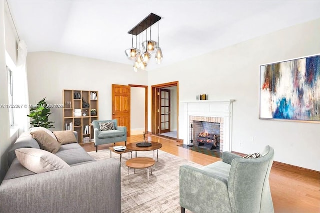118 E 3rd Ct, Miami Beach, FL 33139 - living room with vaulted ceiling, wood finished floors, a fireplace, and a notable chandelier