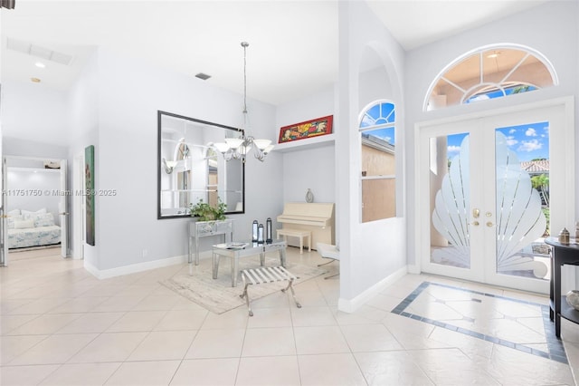 foyer with french doors, an inviting chandelier, visible vents, and baseboards