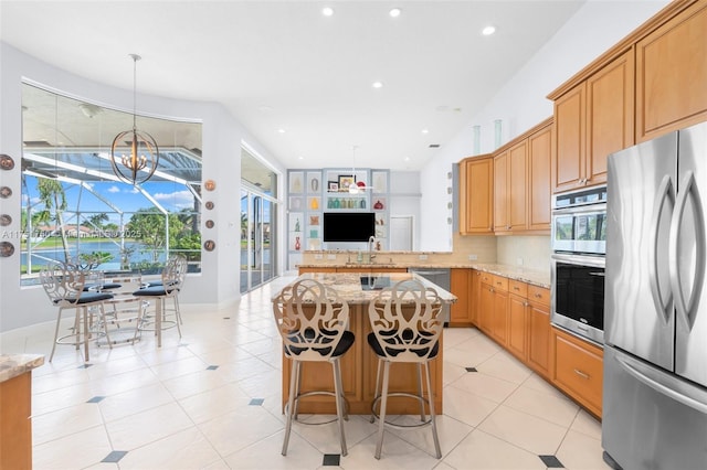 5135 Kensington Cir, Coral Springs, FL 33076 - kitchen with stainless steel appliances, light stone counters, recessed lighting, plenty of natural light, and light tile patterned floors