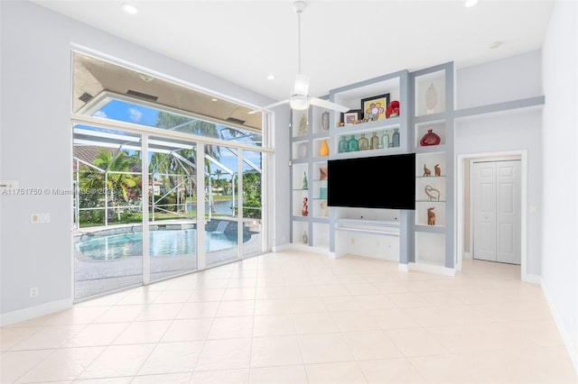 unfurnished living room featuring built in shelves, recessed lighting, a ceiling fan, a sunroom, and baseboards