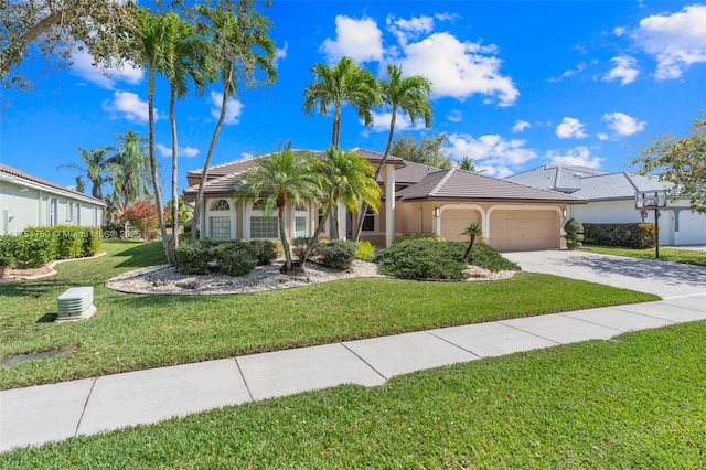 view of front of property featuring a tile roof, stucco siding, a front yard, a garage, and driveway