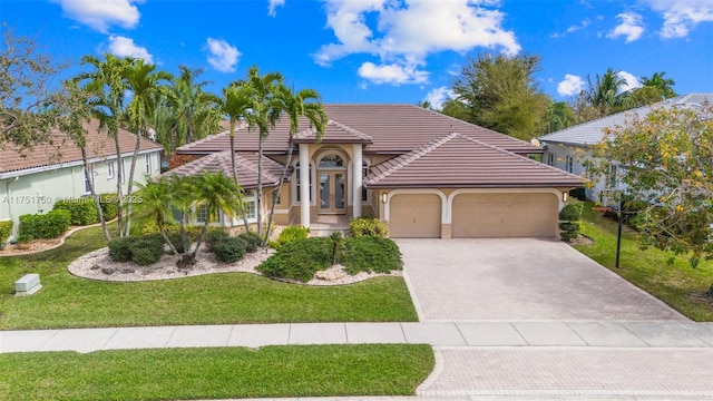 5135 Kensington Cir, Coral Springs, FL 33076 - view of front of home featuring an attached garage, driveway, stucco siding, a front lawn, and a tiled roof