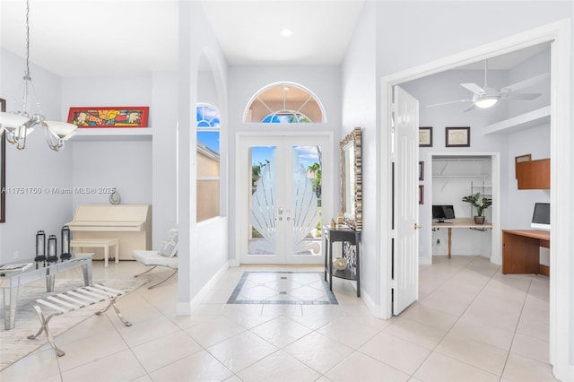 foyer entrance with light tile patterned floors, baseboards, a notable chandelier, and french doors