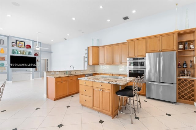 kitchen featuring visible vents, open floor plan, a center island, a peninsula, and stainless steel appliances