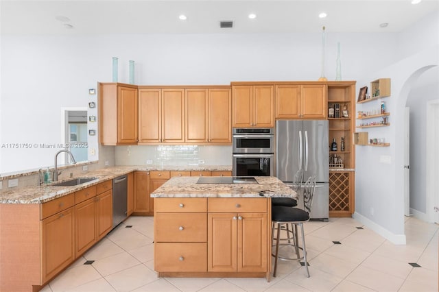 5135 Kensington Cir, Coral Springs, FL 33076 - kitchen with appliances with stainless steel finishes, open shelves, arched walkways, a center island, and light stone countertops