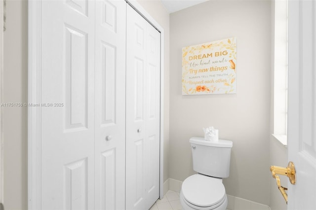 bathroom featuring a closet, tile patterned flooring, toilet, and baseboards