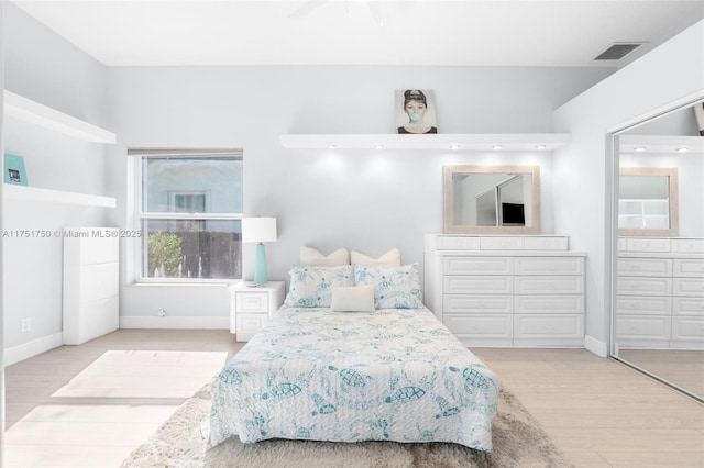 bedroom with light wood-style floors, baseboards, and visible vents