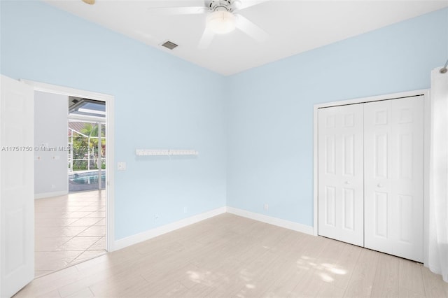 unfurnished bedroom featuring light wood finished floors, baseboards, visible vents, a ceiling fan, and a closet