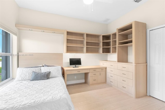 bedroom featuring built in desk and light wood-type flooring