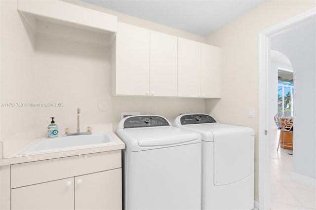 laundry room featuring cabinet space, light tile patterned floors, a sink, and independent washer and dryer