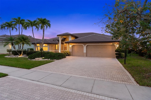 5135 Kensington Cir, Coral Springs, FL 33076 - view of front of house featuring an attached garage, decorative driveway, a front lawn, stucco siding, and a tile roof