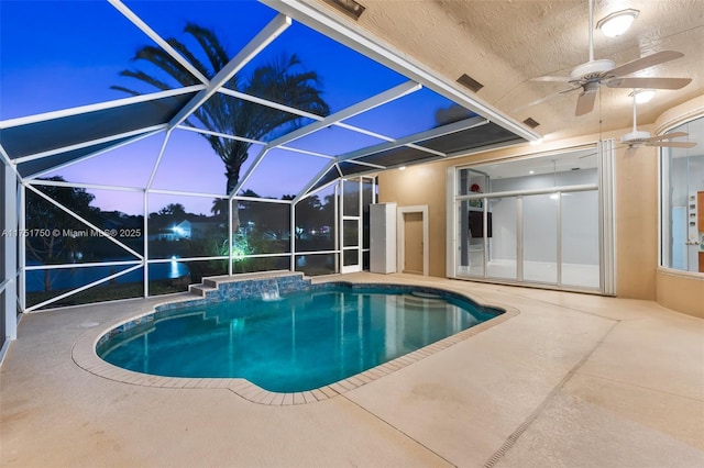 pool at dusk with a lanai, a patio area, and an outdoor pool