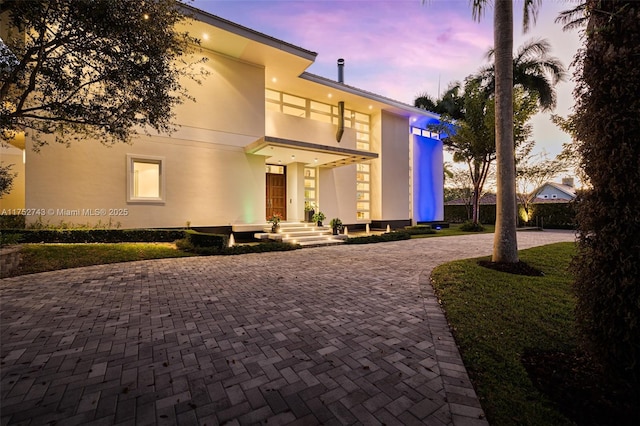 view of front facade featuring decorative driveway and stucco siding