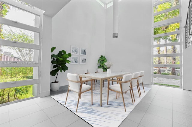 dining space with a towering ceiling and light tile patterned flooring