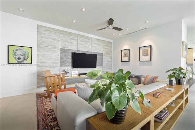 living room featuring ceiling fan, recessed lighting, an accent wall, tile walls, and baseboards