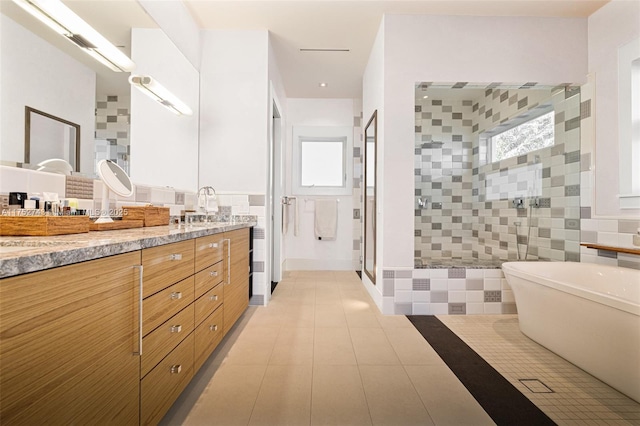 full bath featuring a stall shower, vanity, tile walls, and tile patterned floors