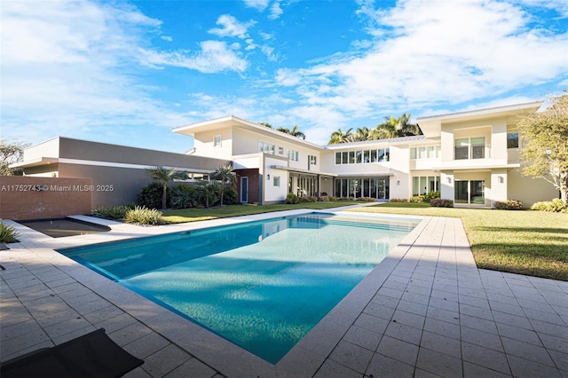 outdoor pool featuring a yard