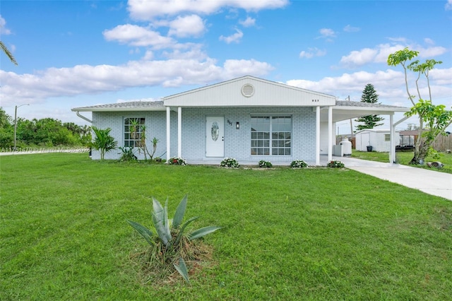 view of front of property with a carport, concrete driveway, brick siding, and a front lawn