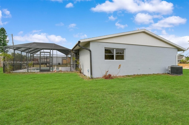 view of side of home featuring central air condition unit, glass enclosure, an outdoor pool, and a yard