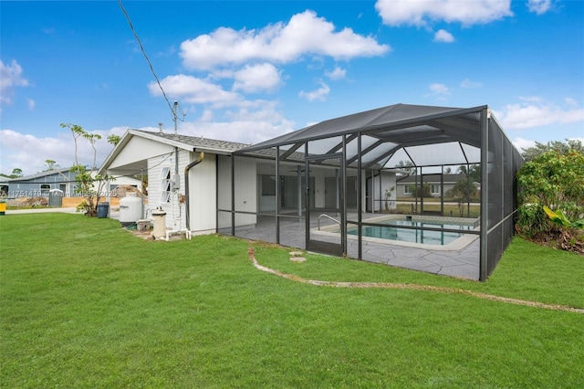 back of house featuring a patio area, glass enclosure, an outdoor pool, and a lawn