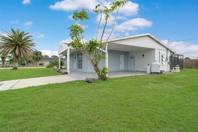 rear view of property featuring a carport and a lawn