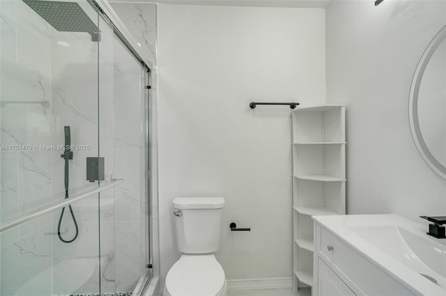 bathroom with a marble finish shower, baseboards, vanity, and toilet