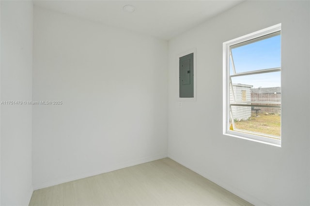 spare room featuring electric panel and baseboards