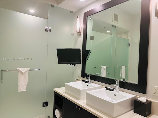 full bath featuring double vanity, a sink, visible vents, and recessed lighting