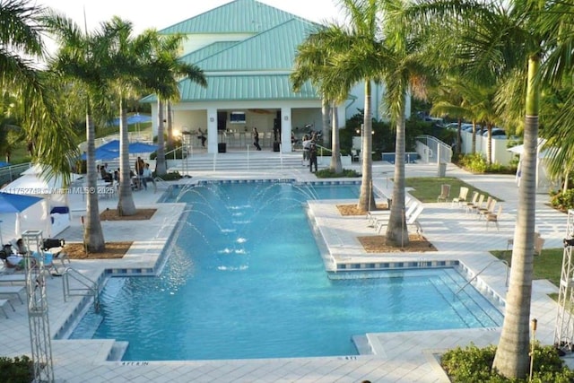 pool with a patio area and fence