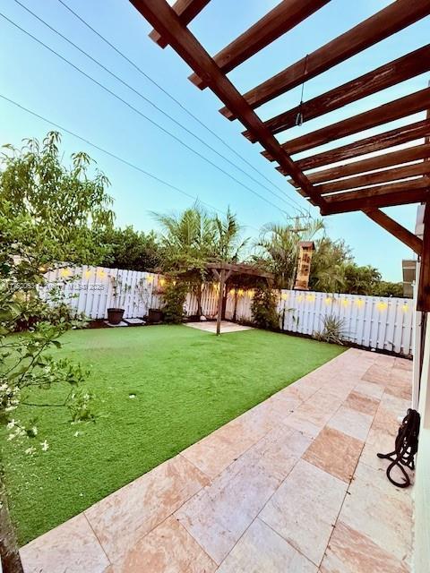 view of yard featuring a patio area, a fenced backyard, and a pergola