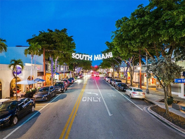 view of road featuring street lights, curbs, and sidewalks