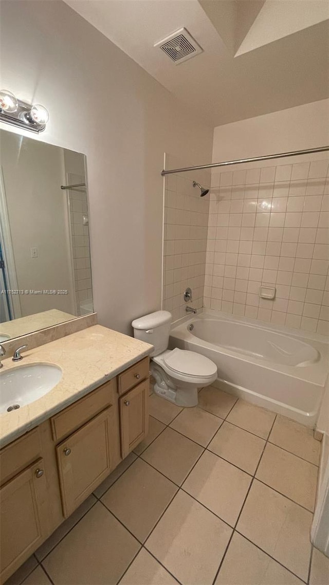 bathroom with tile patterned flooring, toilet, vanity, visible vents, and washtub / shower combination