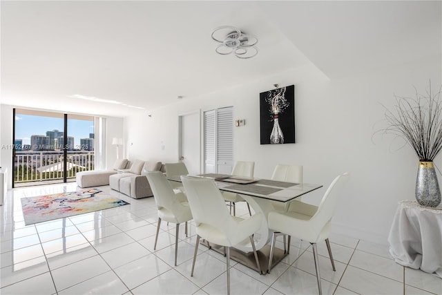 dining room with a view of city, light tile patterned floors, baseboards, and floor to ceiling windows