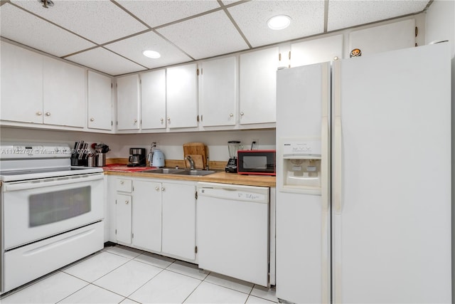 kitchen with white appliances, white cabinetry, light countertops, and a sink