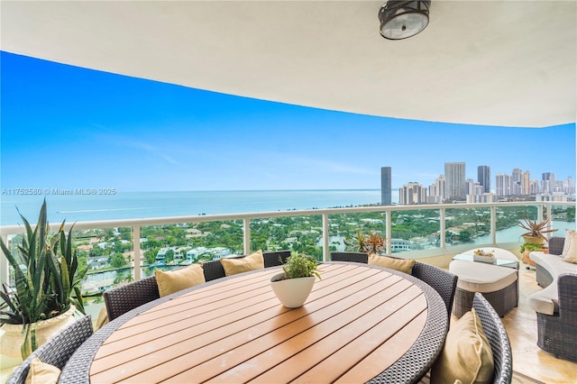 balcony with a water view, a view of city, and outdoor dining area