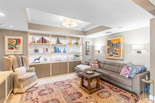 living room with a tray ceiling, visible vents, and crown molding