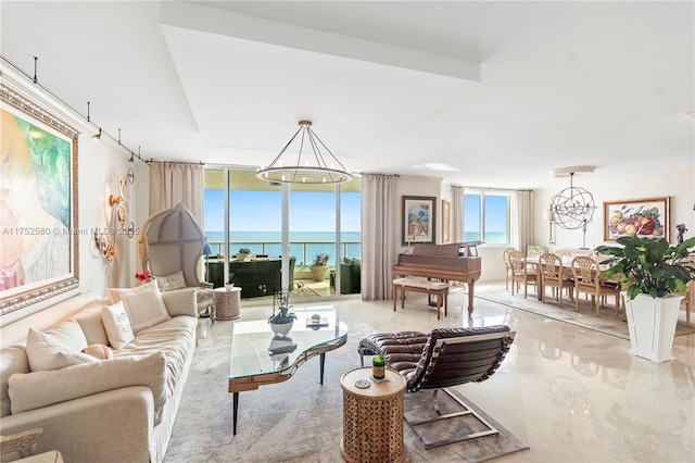 living room with a chandelier, marble finish floor, a water view, and floor to ceiling windows