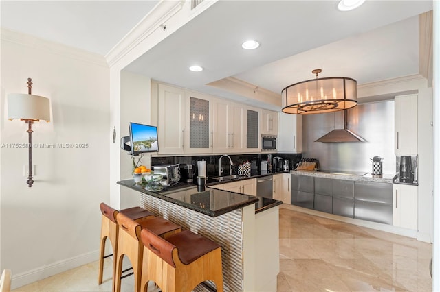 kitchen featuring pendant lighting, a breakfast bar area, glass insert cabinets, built in microwave, and a peninsula